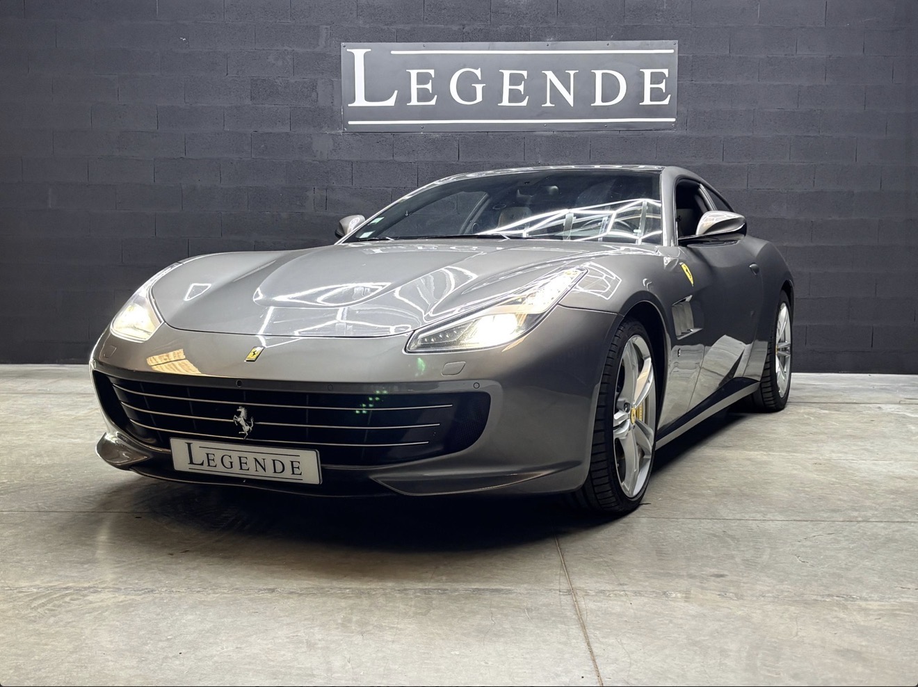 Ferrari GTC4 Lusso grise de trois quarts avant dans le showroom Légende